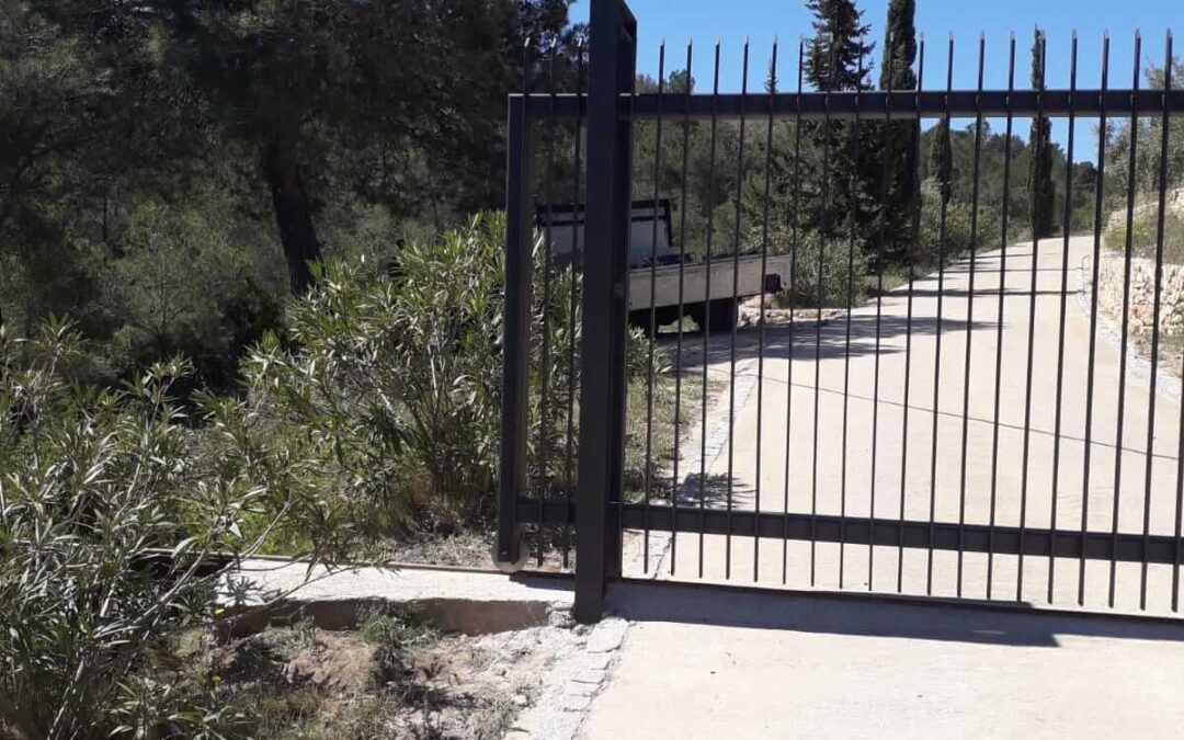 Construcción de puerta y cercado, para una casa de montaña, formada por hierro galvanizado